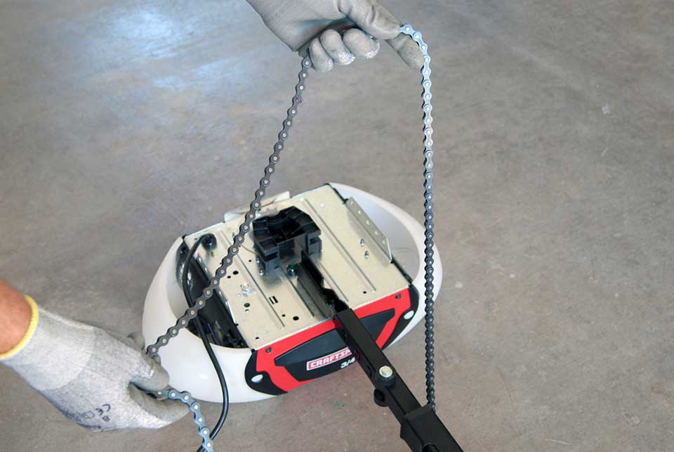 Person installing a chain on a garage door opener.