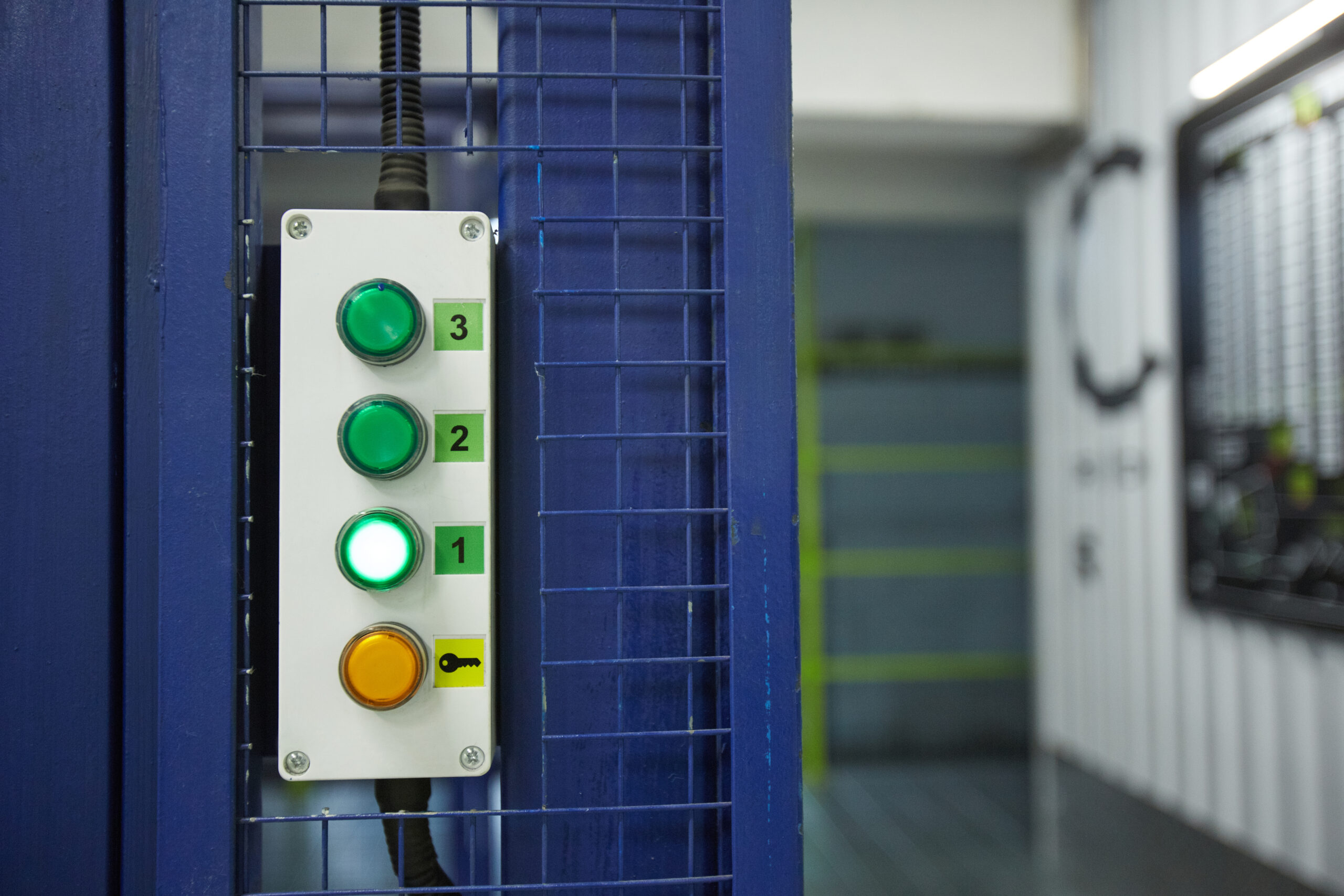 Close-up of a control panel with three green buttons and one orange button.
