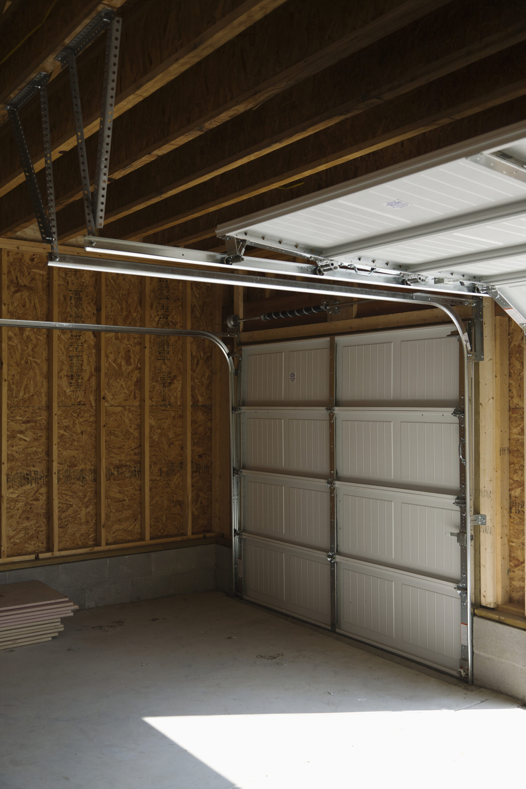 Interior view of a garage with a partially open white door.