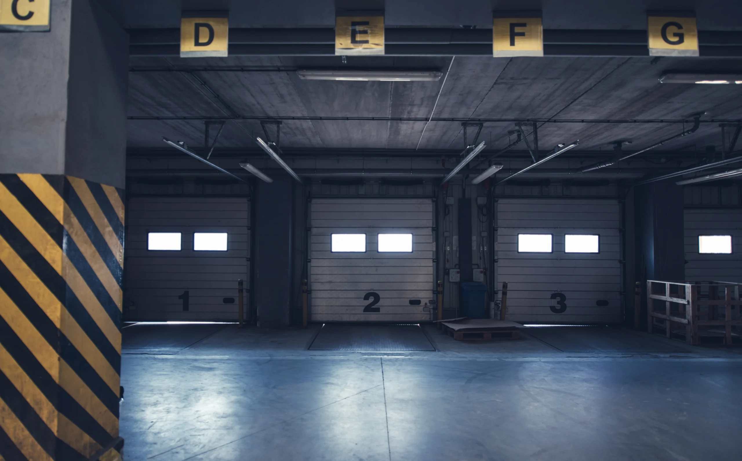 Interior of a loading dock with three numbered garage doors