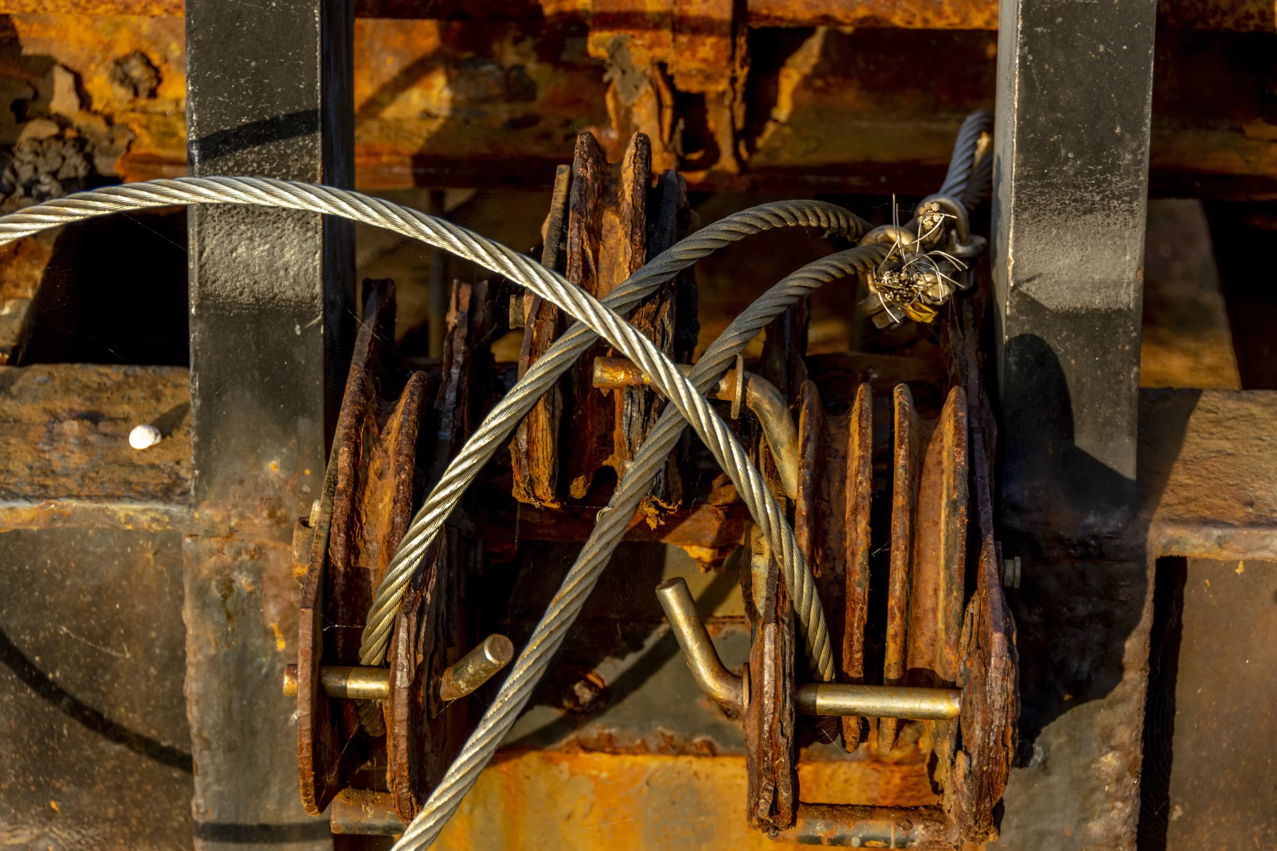 Close-up of rusty metal parts and intertwined steel cables.