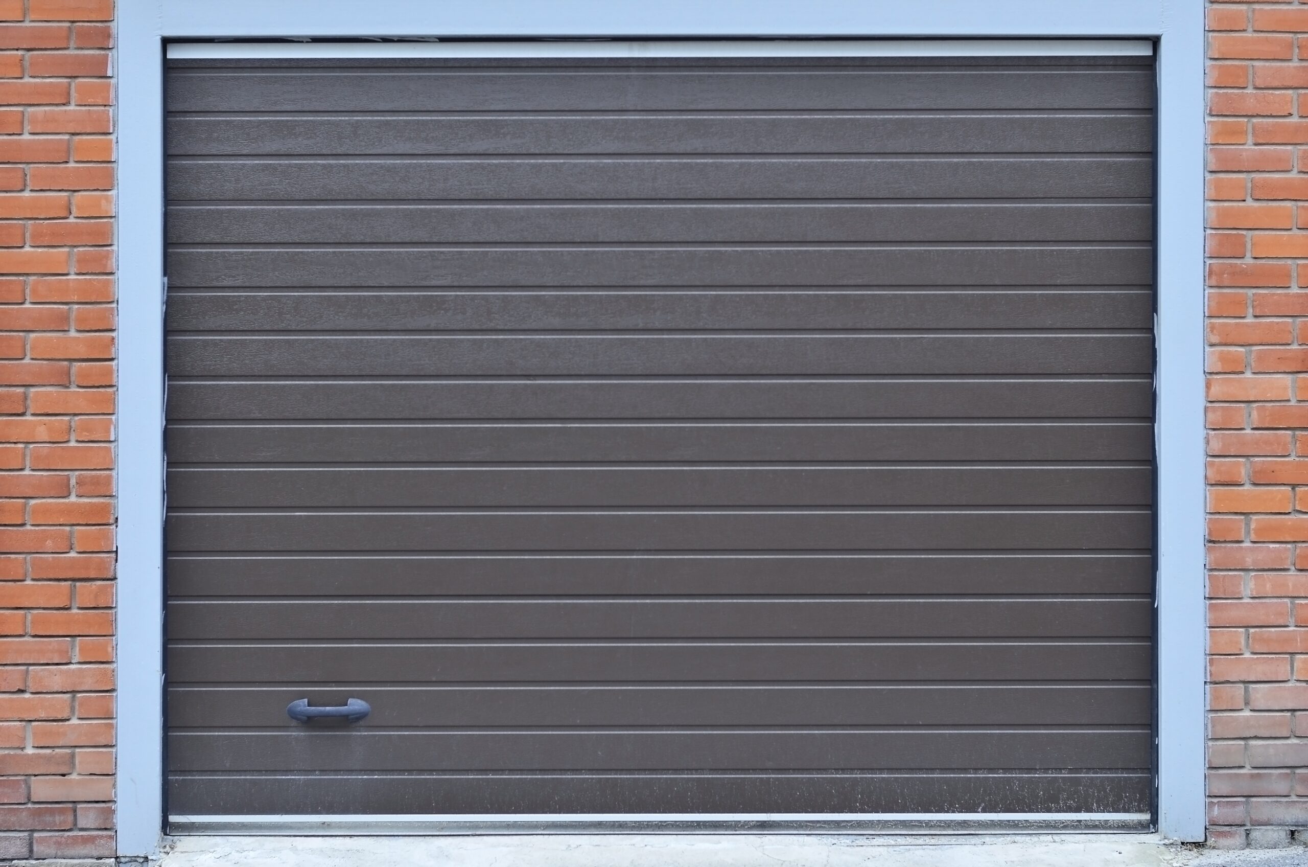 Closed brown garage door with horizontal panels and a handle