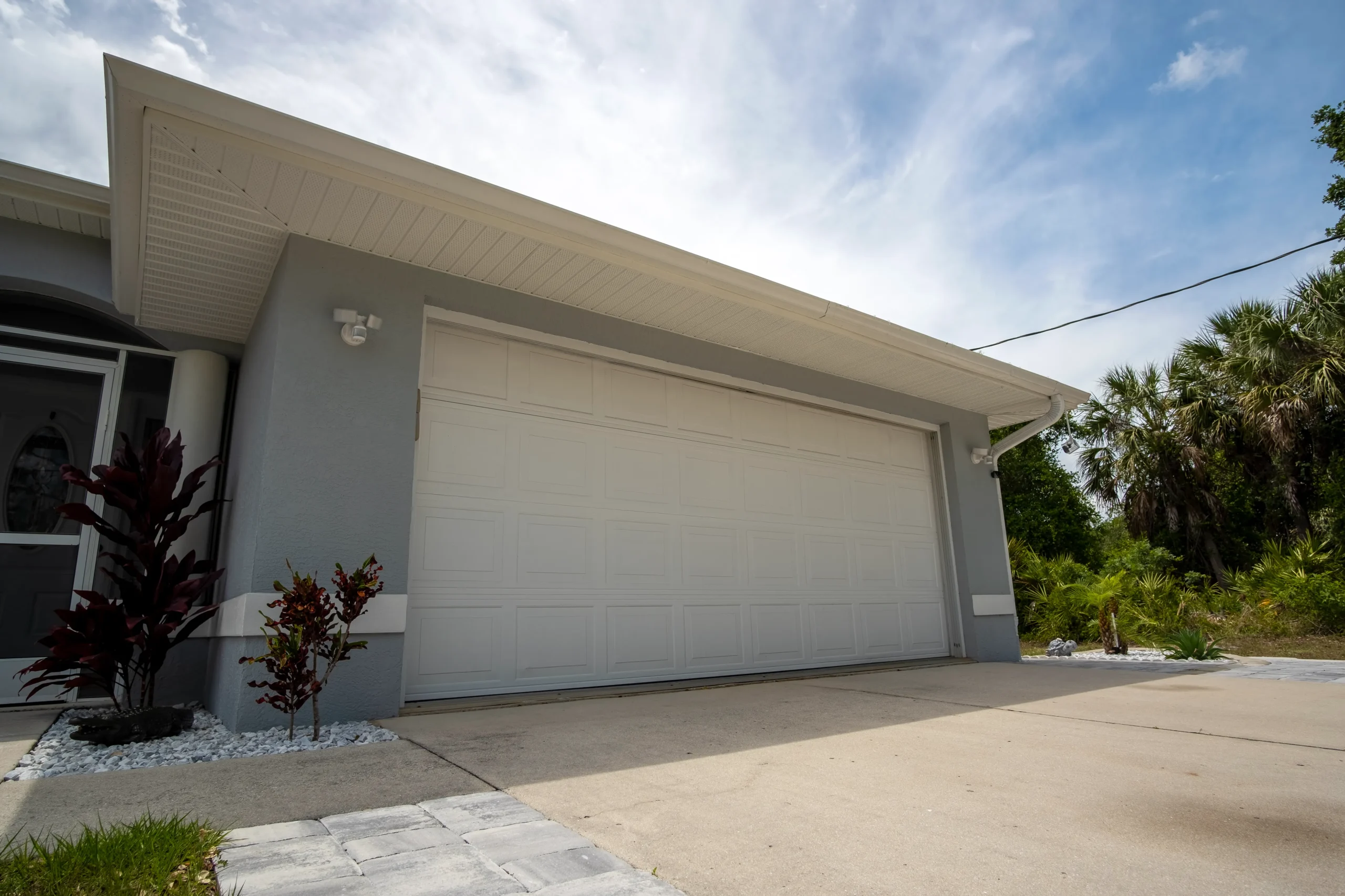 Exterior view of a house with a white garage door and light blue walls.