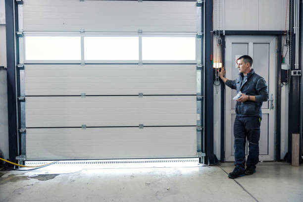 Man operating a large white garage door with windows