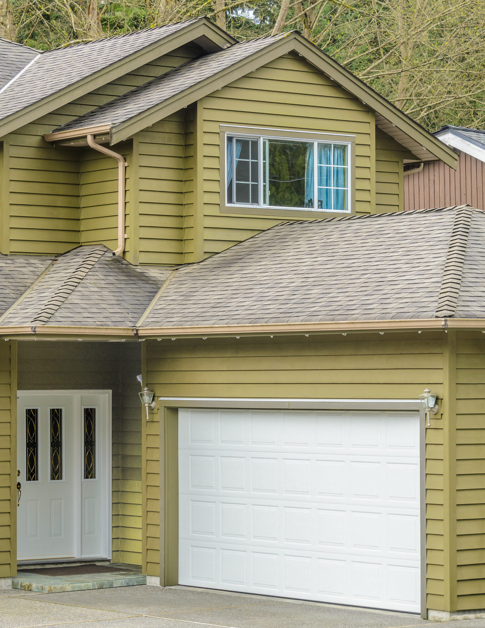 Front view of a two-story house with a white garage door.