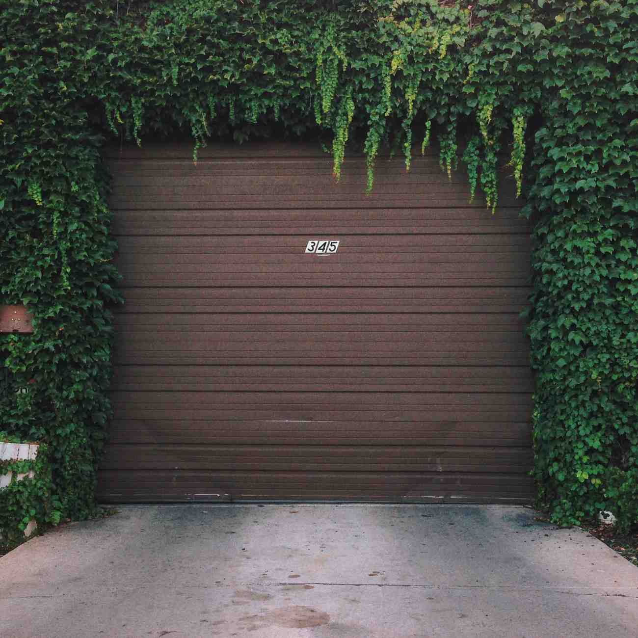 Brown garage door with green ivy on top and sides, house number 345