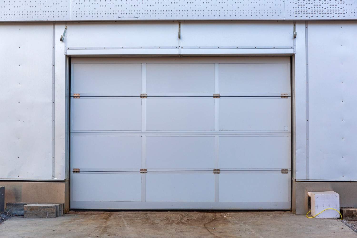 A large, closed white garage door on a commercial building.