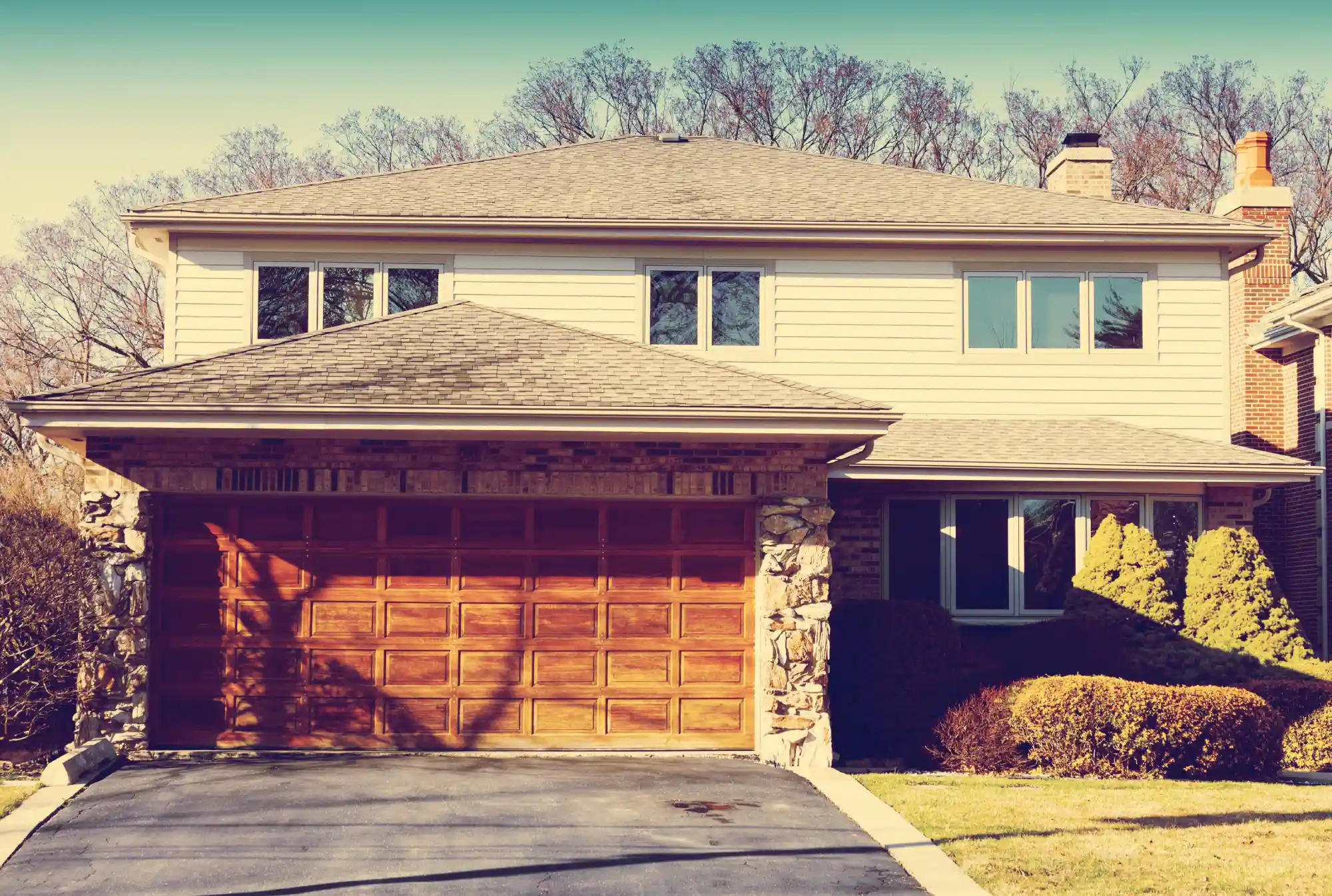 Suburban house with a two-car garage and light-colored siding.