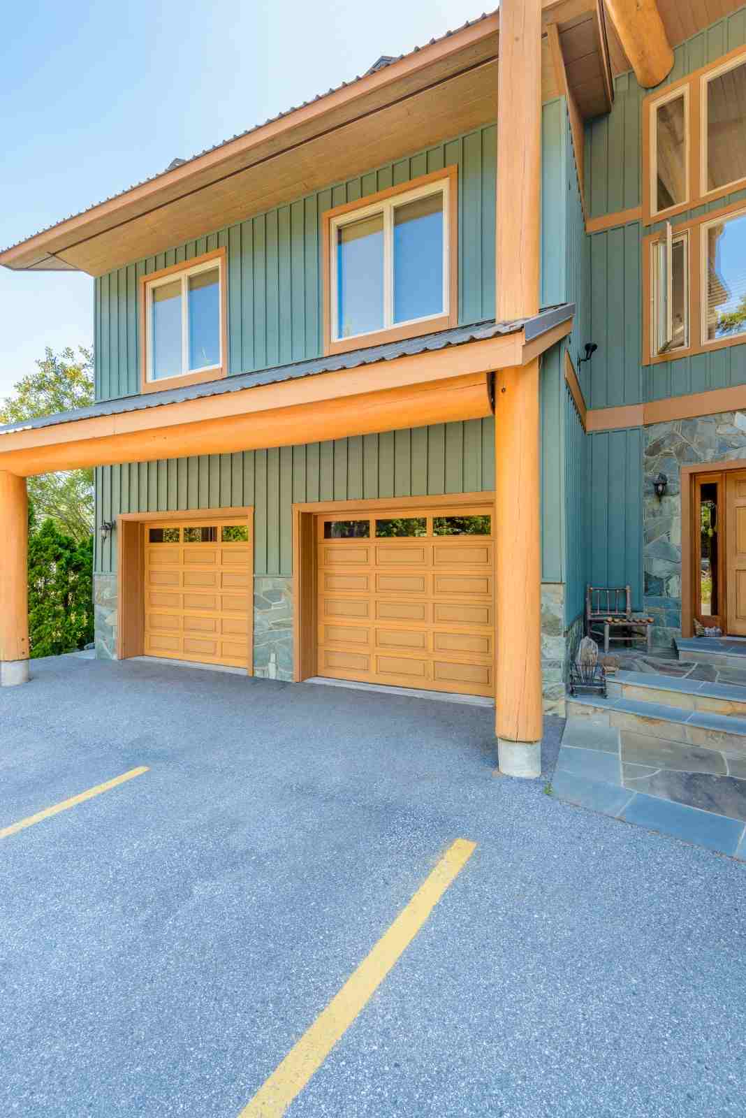 Modern house with two wooden garage doors and a stone entrance.
