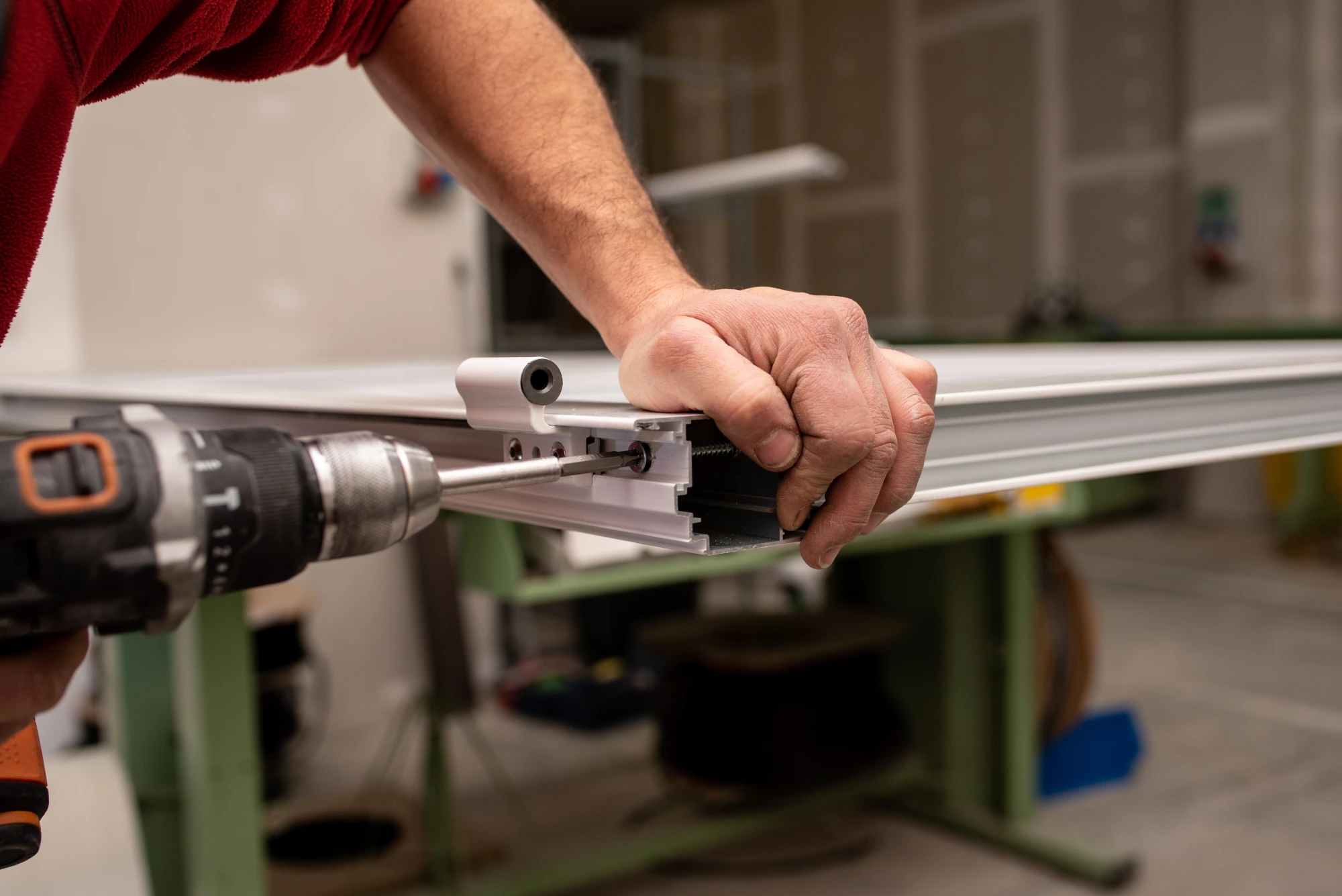 Close-up of a person using a drill to assemble a metal frame