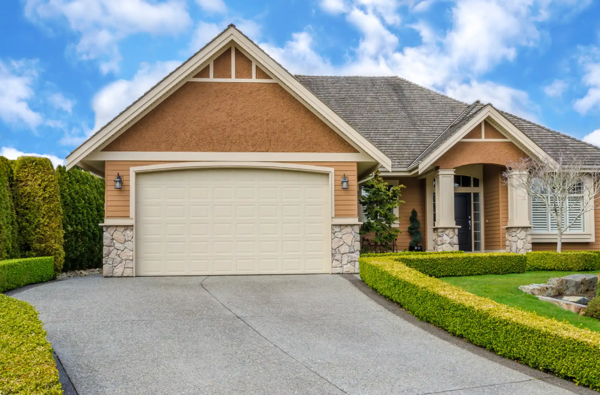 A large, modern house with a two-car garage and a well-maintained lawn.