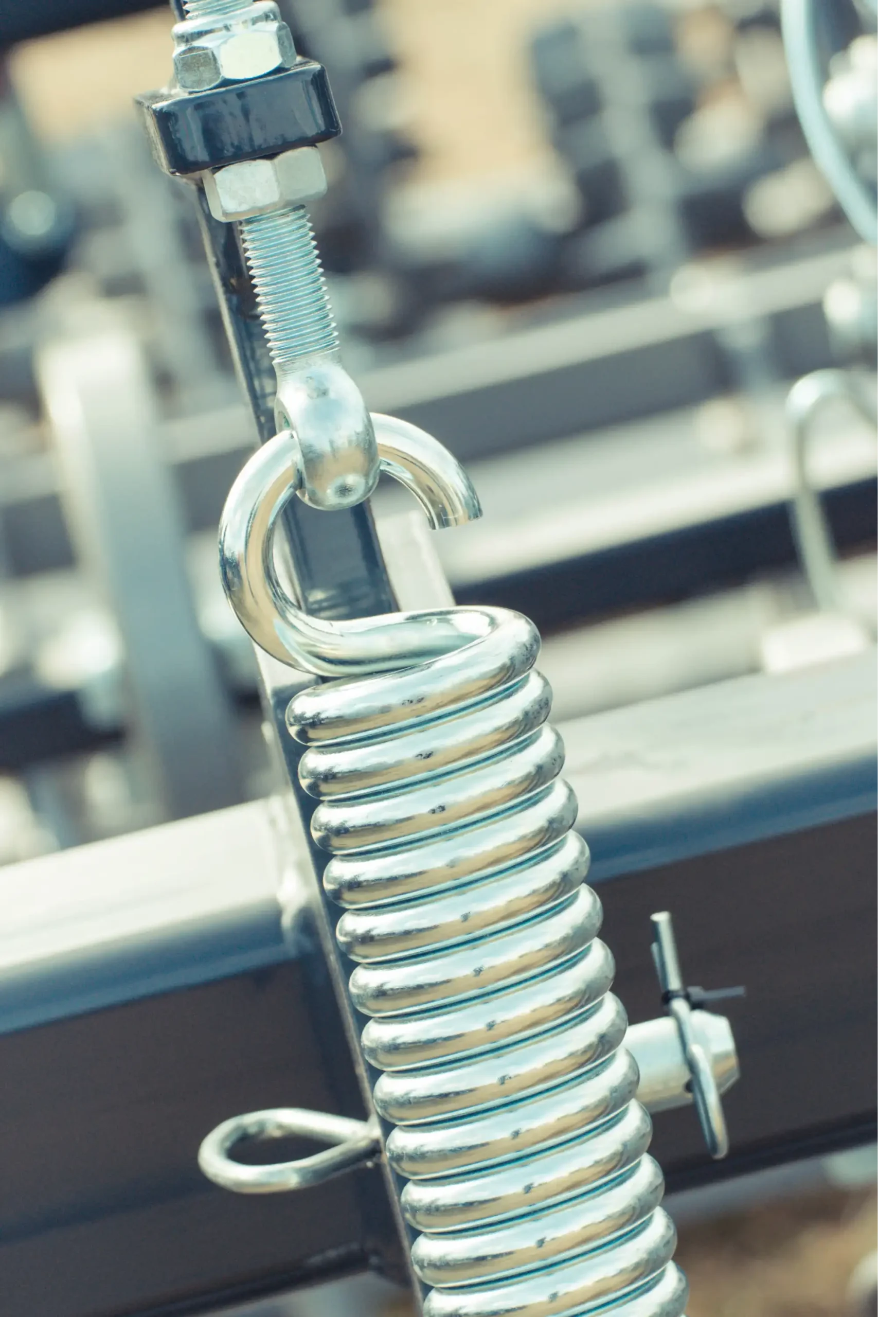 Close-up of a metal spring and bolt on agricultural machinery.