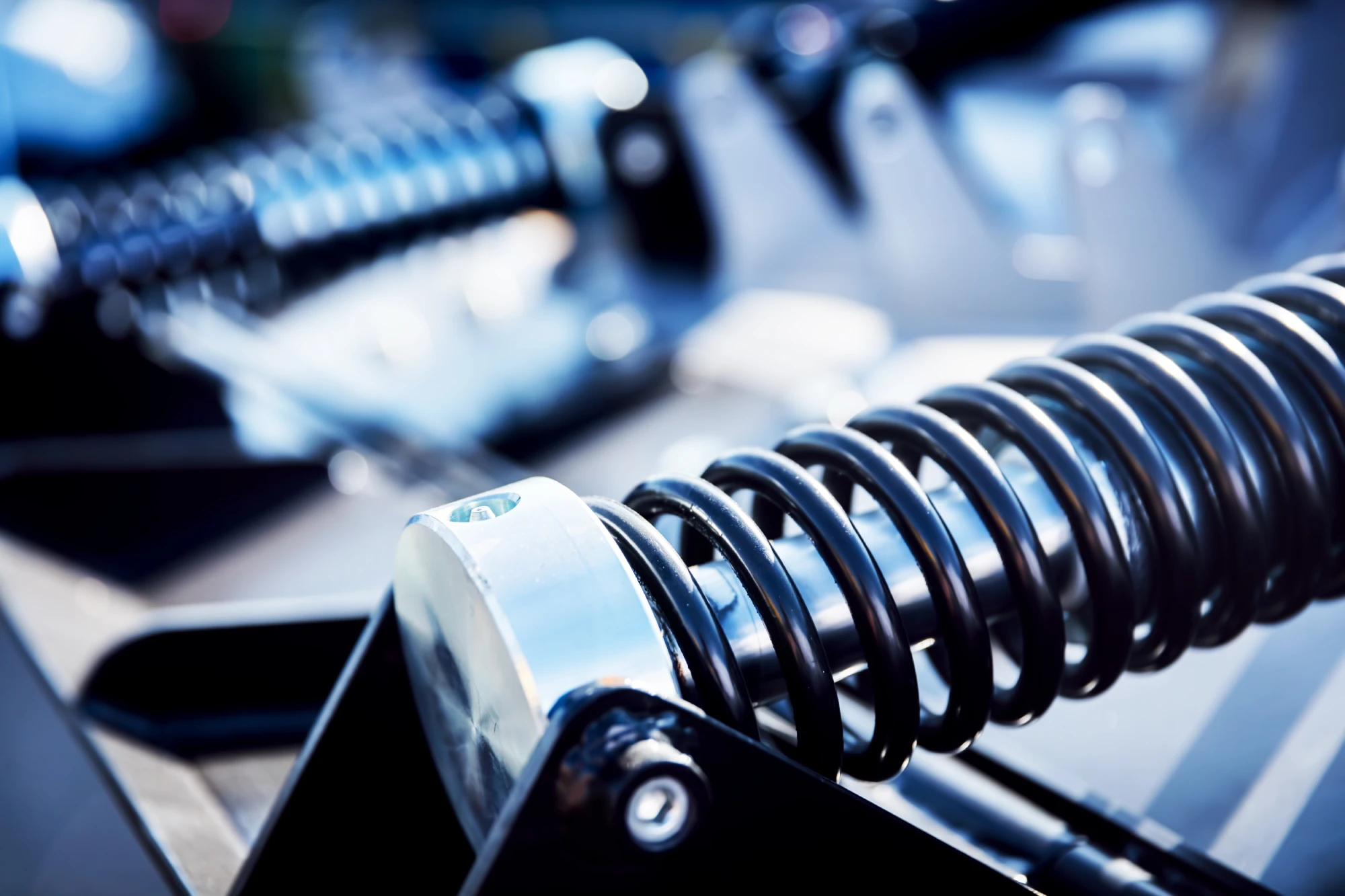 Close-up of a black coil spring and metal components on machinery