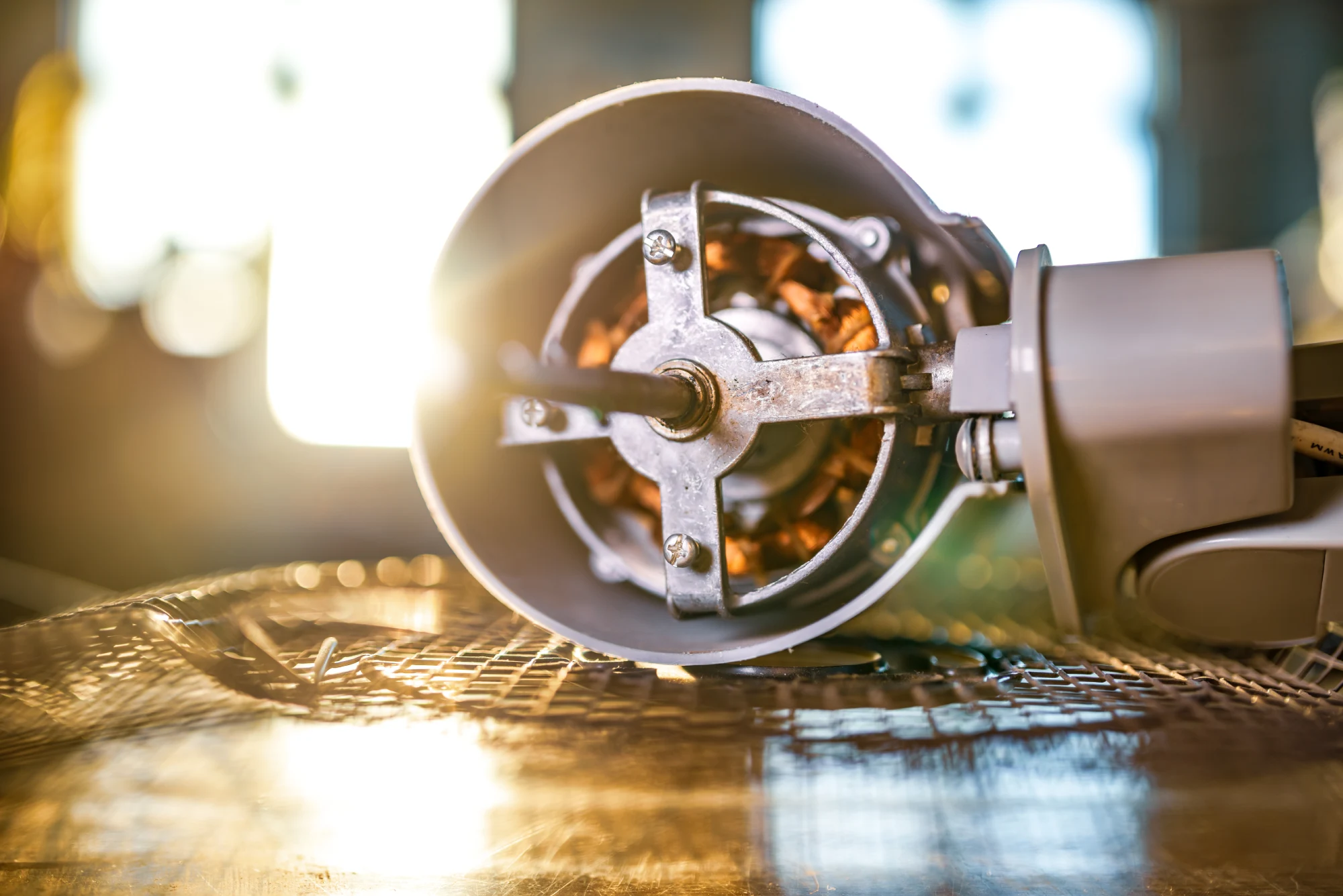Close-up of a motor with visible copper wiring and a metal frame