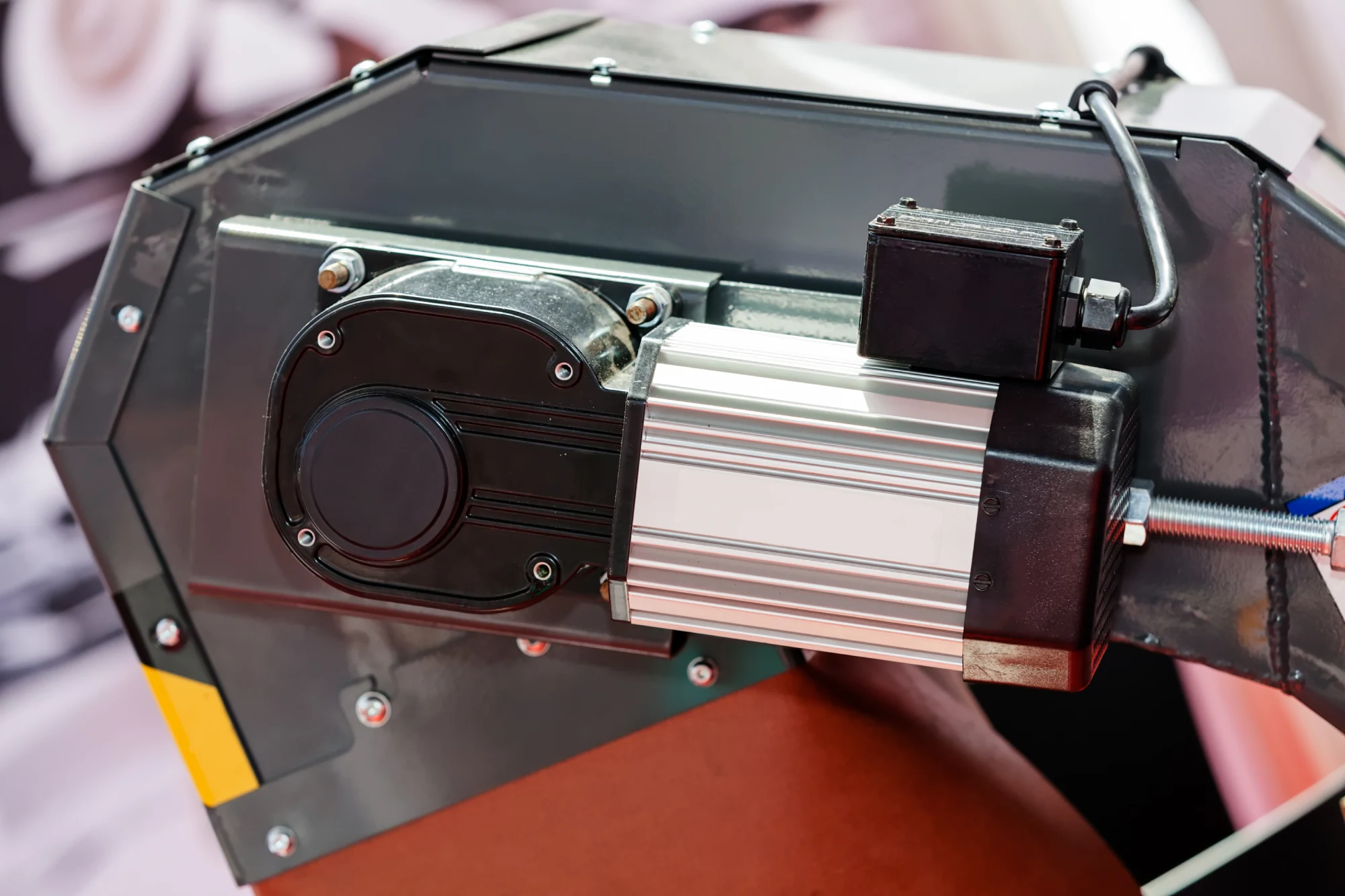 Close-up of a black and silver industrial motor with wires and bolts.